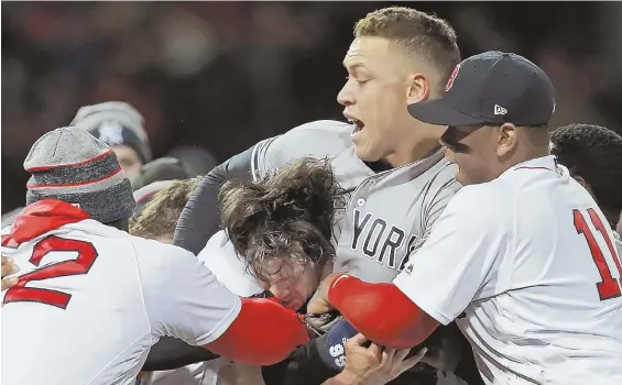  ?? STaff fILE phoTo By MaTT sToNE ?? UNRIVALED INTENSITY: The Yankees’ Aaron Judge wrestles with reliever Joe Kelly while other Red Sox try to intervene during a battle between the teams in April at Fenway. The teams resume their rivalry tonight with the start of a three-game series at...