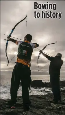  ?? Picture by Patrick Browne ?? Two members of the Dunbrody Archers firing arrows into the sea at Hook Head in a centuries-old tradition dating back to 1687 when the mayor and the members of New Ross Town Council claimed their authority over the tower and waters by travelling to the point of the Hook and shooting an arrow into the sea from Hook Head Lighthouse.