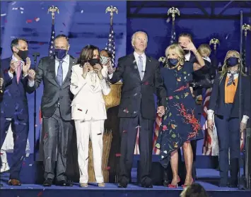  ?? Tasos Katopodis / Getty Images ?? President-elect Joe Biden, Jill Biden, Vice President-elect Kamala Harris and husband Doug Emhoff wave to the crowd on stage after Biden's address to the nation Saturday.