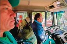  ??  ?? Jose Alberto Gutierrez (right) accompanie­d by a fellow garbage collector drives a garbage truck through the streets of Bogota.