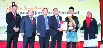  ??  ?? Rosli (second right) receives his award from Mataip.