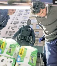  ?? ?? WIPED: Cops restrain a man with many packs of Bounty paper towels apparently taken in a 10:20 a.m. heist Tuesday from a CVS store on Lexington Avenue near 87th Street. The NYPD did not confirm any arrests in the theft of $227 worth of paper towels from the store. But a Post photograph­er took this photo (left) in the afternoon.