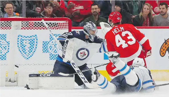  ?? PAUL SANCYA / THE ASSOCIATED PRESS ?? Despite Tuesday’s loss to Detroit, Connor Hellebuyck, left, and the Winnipeg Jets have shored up their defensive woes and find themselves near the top of the NHL standings.