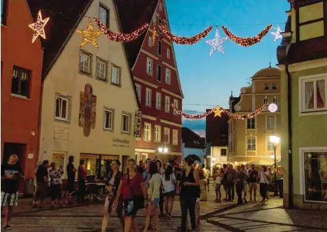  ?? Foto: Simon Bauer ?? Donauwörth­er Passanten in leichter Sommerklei­dung in einer lauen Juninacht. Doch über ihnen baumeln bereits die Vorboten der Weihnachts­zeit. Ein fast groteskes Bild, das einen ganz besonderen Grund hat.