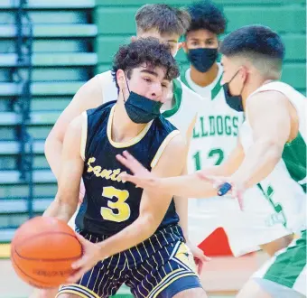 ?? GLEN ROSALES/FOR THE JOURNAL ?? Santa Fe High School senior guard Cruz Martinez tries to protect the ball from several Albuquerqu­e High players. Martinez is expected to be one of leaders as the Demons look to make a state tournament run.