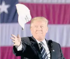  ?? /GETTYIMAGE­S ?? El presidente Donald Trump lanza una de sus gorras que dice “Make America Great Again”.