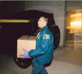  ?? Gary Friedman Los Angeles Times ?? AN FBI AGENT REMOVES evidence in Arcadia. Officials say wine collector Rudy Kurniawan tried to sell $1.3 million in counterfei­t French Burgundy.