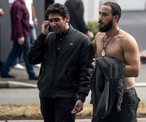  ?? GEORGE HEARD/STUFF ?? A distraught mosque attendee is comforted by a friend as he speaks on the phone after the shooting at the Al Noor Mosque.