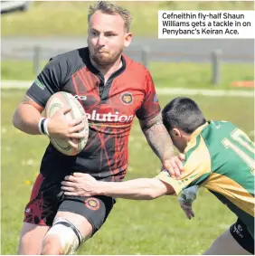  ??  ?? Cefneithin fly-half Shaun Williams gets a tackle in on Penybanc’s Keiran Ace.