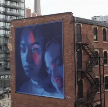  ?? NICK KOZAK PHOTOS/TORONTO STAR ?? A public installati­on photograph called Jackie and Anna ( rainbow tear) by Petra Collins towers over the intersecti­on of King St. and Spadina Ave. as part of her exhibition.