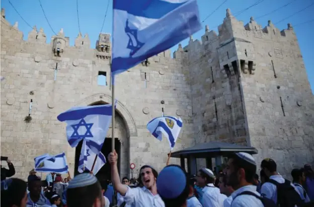  ?? © ap ?? Israeli’s verwelkome­n de nieuwe wet met vlaggenver­toon in Jeruzalem.