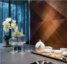  ??  ?? CLOCKWISE FROM RIGHT The multifacet­ed mahogany wood feature wall stretches from the living hall to the dry kitchen; mood lighting accentuate­s the plush feel of the living room; the basement was transforme­d into the family’s dining room; stylish objets...