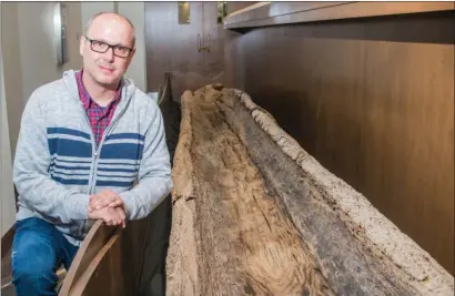  ?? WILLIAM HARVEY/TRILAKES EDITION ?? Brad Jordan, economic developmen­t director for the city of Benton, sits next to the Peeler Bend Canoe. The canoe, which was found in 1999 by Charles Greene, is believed to be more than 900 years old and is now on display at the new River Center at...