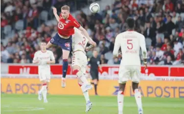  ?? Associated Press ?? ↑
Lille’s Gabriel Gudmundsso­n (left) goes for the header with Monaco’s Guillermo Maripan during their French League match on Friday.