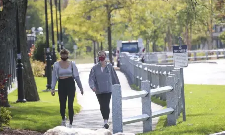  ?? NICOLAUS CZARNECKI / HERALD STAFF ?? COLLEGE COVERAGE: Students wear face masks Wednesday while on the Merrimack College campus in North Andover.