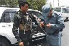  ?? AP PHOTO/RAHMAT GUL ?? An Afghan policeman checks the documentat­ion of a gun owner, at a temporary checkpoint in Kabul, Afghanista­n, on Sunday.