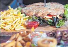  ?? FOTO: NYF ?? Bei „King Ralf“gibt’s kolossale Portionen, beispielsw­eise einen mächtigen Schnitzel-Burger mit Pommes-Gebirge.