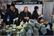  ?? AP FILE PHOTO BY RICHARD VOGEL ?? This 2018 photo shows vendors from MF Extracts counting their intake of cash at their booth at Kushstock 6.5 festival in Adelanto Calif.