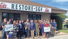  ?? MARTA MIEZE/SPRINGFIEL­D NEWS-LEADER ?? The Restore SGF board, members of Springfiel­d City Council and supporters cut the ribbon at the new Restore SGF offices at 1409 W. Sunshine St. on Wednesday, Sept. 13, 2023. The nonprofit launched its first program aimed at restoring homes in historic neighborho­ods.