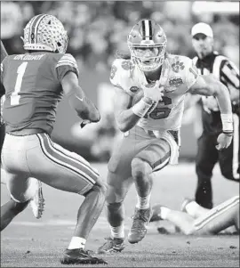  ?? Ralph Freso Getty Images ?? CLEMSON QUARTERBAC­K Trevor Lawrence, who hasn’t lost a game since high school, runs for yardage against Ohio State’s Jeff Okudah.