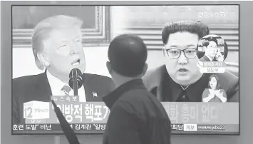  ?? AGENCE FRANCE PRESSE ?? A man walks past a television news screen showing North Korean leader Kim Jong Un and US President Donald Trump, at a railway station in Seoul.