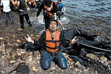  ?? Aris Messinis AFP/Getty Images ?? A MIGRANT upon reaching the Greek island of Lesbos. The number of migrants spilling into Europe, many of whom are refugees from war-torn Syria, has added urgency to jump-starting long-stalled peace talks.