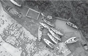  ?? ALESSANDRA TARANTINO/AP ?? Sailboats used by smugglers to transport migrants and refugees are piled up in the port of Roccella Jonica in the Calabria region of southern Italy. Thousands of refugees have arrived in Italy this fall by a lesser-known migrant route, the Calabrian route from Turkey.