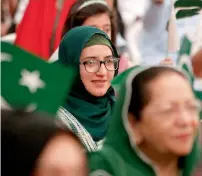  ?? Photos by M.Sajjad and Ryan Lim ?? Women clad in green scarves show solidarity to their homeland during the celebratio­ns. —