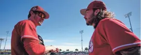  ?? SAM GREENE/THE ENQUIRER ?? Reds right fielder Wil Myers and second baseman Jonathan India discuss fly balls before taking the field for a spring training game.