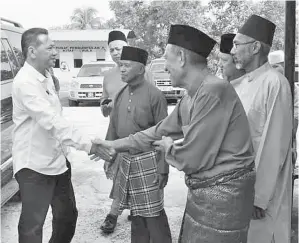  ??  ?? (Gambar atas) KETIBAAN Awang Husaini (kiri) disambut mesra oleh AJK KRT.
(Gambar kanan) AWANG Husaini bersama Hilman menyampaik­an duit raya kepada kanak-kanak yang hadir.