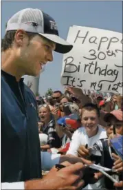  ?? STEPHAN SAVOIA — THE ASSOCIATED PRESS FILE ?? In this file photo, New England Patriots quarterbac­k Tom Brady signs autographs for fans after a practice session on his birthday at the NFL football team’s training camp in Foxborough, Mass. Winning a fifth NFL championsh­ip ring and a fourth Super...