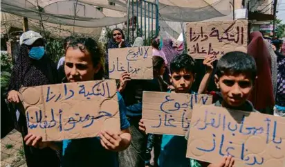  ?? SAEED JARAS/MIDDLE EAST IMAGES/AFP VIA GETTY IMAGES ?? Palestinia­ns held signs saying “Decision makers, we need fuel” during a rally in central Gaza.