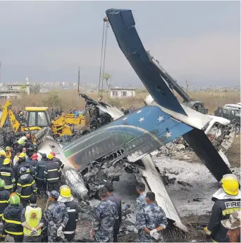  ?? AFP ?? Nepalese rescue workers gather around the debris of the US-Bangla Airlines plane that crashed at Tribhuvan Internatio­nal Airport yesterday and burst into flames, killing 49 people