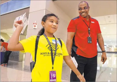  ?? Michael Blackshire Las Vegas Review-journal ?? Malia English, 8, practices throwing a paper plane Wednesday with volunteer Frederick Kuforiji for the seventh annual Paper Plane Palooza in Terminal 3 at Mccarran Internatio­nal Airport. Children competed in distance and accuracy challenges.