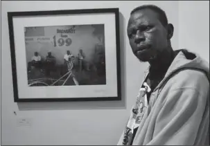  ?? The Associated Press ?? FIRST HAND EXPERIENCE: William Hardy, who is homeless, poses for a portrait in front of one of his photos, on April 11 at the Lemieux Galleries, in New Orleans. Hardy was given a camera and has sold prints in the gallery. His works are part of an...