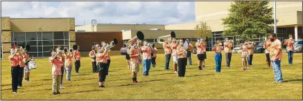  ??  ?? Members of the Gravette High School band, under the direction of bandleader Aaron Ray, perform the school fight song on the campus in front of the school.