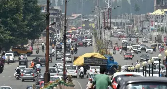  ?? — AFP photo ?? Residents drive along a busy road in Srinagar.