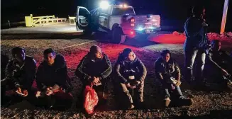  ?? Gregory Bull / Associated Press ?? Migrants wait to be processed after crossing the border on Jan. 6, near Yuma, Ariz. The Biden administra­tion says it will generally deny asylum to migrants who show up at the U.S. southern border without first seeking protection in a country they passed through. That mirrors an attempt by the Trump administra­tion that never took effect because it was blocked in court.