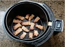  ??  ?? An air fryerisa healthier wayto cook meats because bacon and other meats don’t cook in their own fat as they wouldin a frying panor skillet.