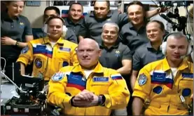  ?? ?? BOLD STATEMENT: Russian astronauts, from left, Sergey Korsakov, Oleg Artemyev and Denis Matveev, in their yellow uniforms on the Space Station