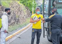  ??  ?? • Byron Castillo, lateral de Barcelona, es desinfecta­do al descender de un bus antes de ingresar al estadio.