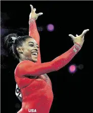  ?? Laurence Griffiths / Getty Images ?? Biles flashes a smile after executing a “calm, peaceful landing” during her gold medal winning vault performanc­e in Stuttgart, Germany.