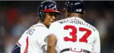  ?? TODD KIRKLAND — THE ASSOCIATED PRESS ?? Atlanta’s Ozzie Albies (1) rounds third and shakes hands with coach Ron Washington (37) after hitting a solo home run Wednesday in Atlanta.