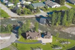  ?? AP PHOTO/DAVID GOLDMAN ?? A house sits in Rock Creek Thursday after floodwater­s washed away a road and a bridge in Red Lodge, Mont