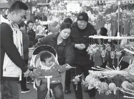  ?? LIU JIANHUA / FOR CHINA DAILY ?? Consumers check out festive products in Nanjing, Jiangsu province, on Friday.