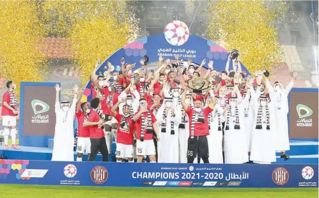  ??  ?? ↑
Al Jazira players celebrate with the trophy after winning the Arabian Gulf League crown following their victory over Khorfakkan.