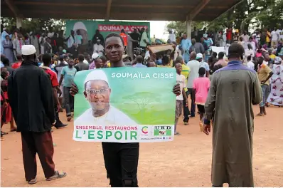  ?? AP Photo/Baba Ahmed, File ?? ■ A supporter of Soumaila Cisse, opposition presidenti­al candidate with Union for the Republic and Democracy party, holds a poster that reads “Together, let’s restore hope,” during an election campaign rally July 16 in Yanfolila, Mali. Mali’s first round of voting last month saw electoral agents killed and voting materials destroyed by extremists linked to al-Qaida, and now in a run-off round two election today, incumbent President Ibrahim Boubacar Keita faces off against Soumaila Cisse.