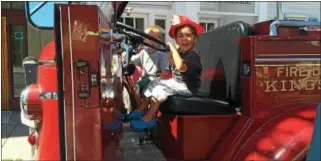  ?? PATRICIA DOXSEY—DAILY FREEMAN ?? Sam Gallo, 2, son of Chris and Karen Gallo of Saugerties, shares a smile as she moves the steering wheel of an engine during the 13th Annual Firemen’s Museum Antique Fire Engine Muster on Saturday on Fair Street in Uptown Kingston. Sitting with Sam is...