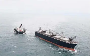  ?? JAPAN COAST GUARD ?? A cargo ship broke apart after running aground in a northern Japanese port and is spilling oil into the sea, Japan’s coast guard said Thursday. All 21 Chinese and Filipino crew members were rescued by the coast guard, said the ship’s Japanese operator, NYK Line. The 39,910-ton Crimson Polaris went aground Wednesday while sailing inside Hachinohe Port.