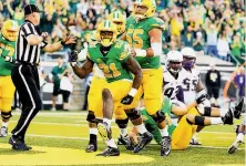  ?? Ryan Kang / Associated Press ?? Oregon freshman Royce Freeman (21) high-steps after scoring a second-quarter touchdown, one of four he had in the game.